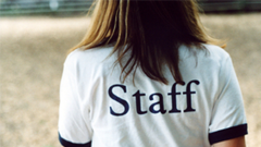 Woman wearing "staff" shirt 